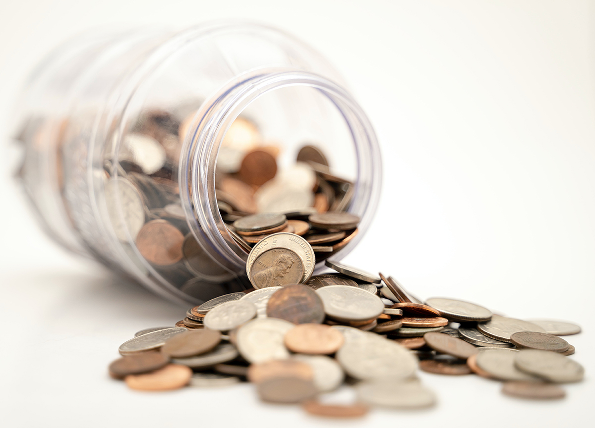 A tilted jar full of coins.